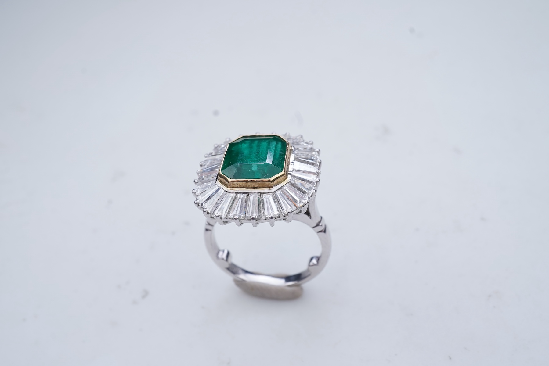 An emerald and diamond ring